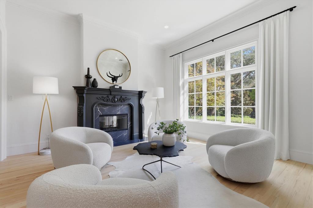 An intimate formal living room pairs garden views with a richly detailed fireplace. An intimate formal living room pairs garden views with a richly detailed fireplace.