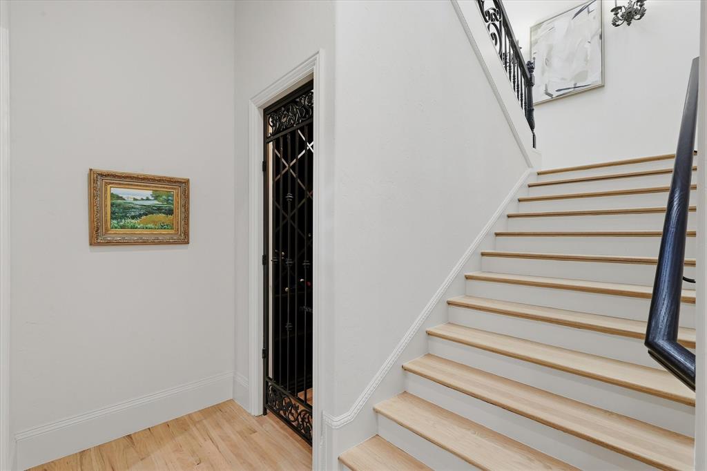 The dedicated wine cellar is discreetly tucked beneath the staircase behind an ornamental iron door.