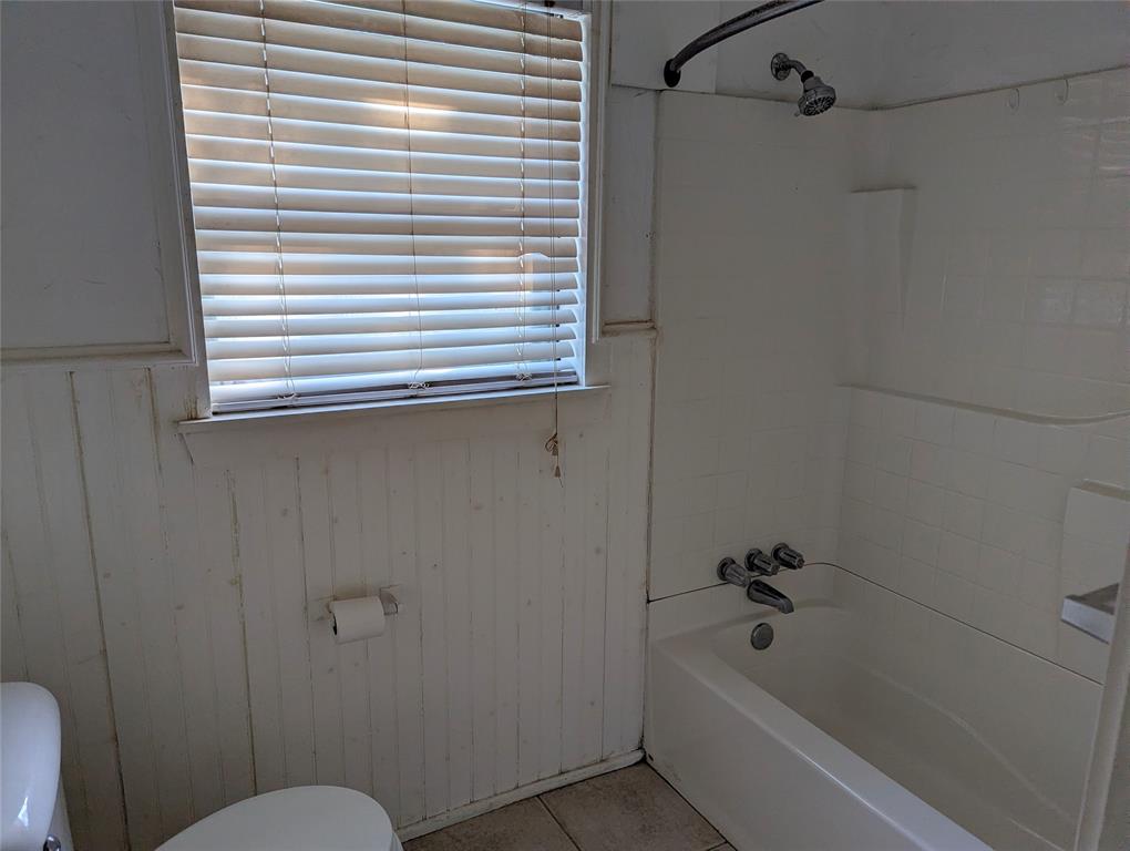 Tub and shower combination with a window for natural light. Ready for renovation and your personal design touches!