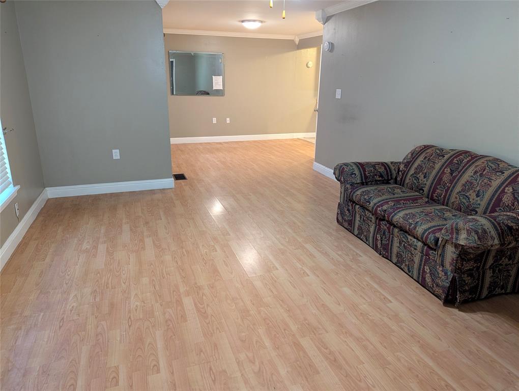 Generously sized living area with wood-look flooring, neutral tones, and flexible space to make your own.