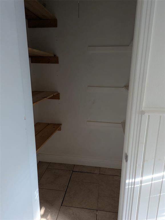 Convenient linen closet with built-in shelving and access to the crawl space serving this section of the home.