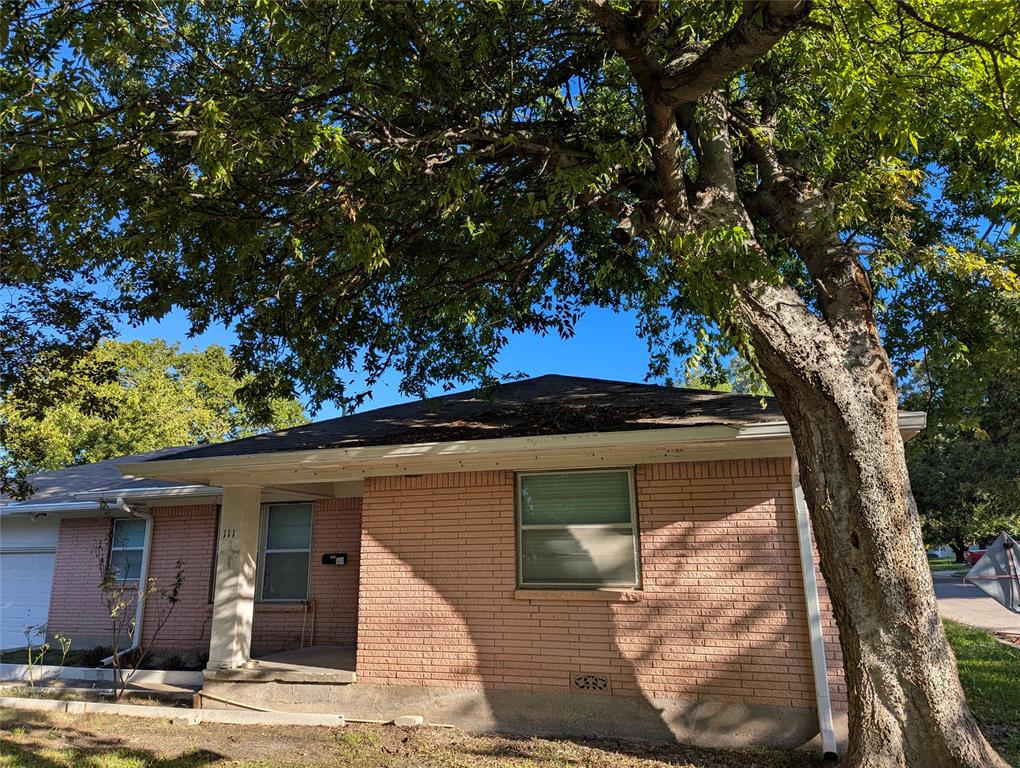 Mature trees provide abundant shade and character to this brick home, complete with a covered front porch and corner-lot setting.