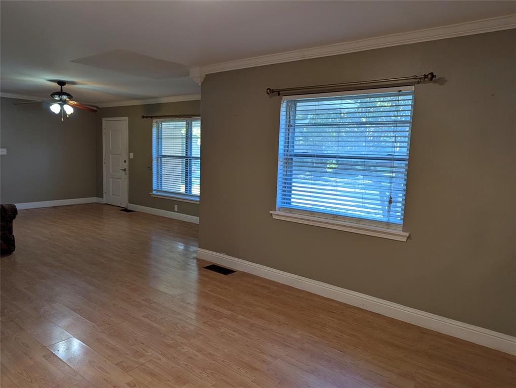 Open & Spacious living and dining rooms featuring wood-look flooring, neutral wall colors, crown molding and large windows welcomes natural light, creating a comfortable space ready for your personal touches!