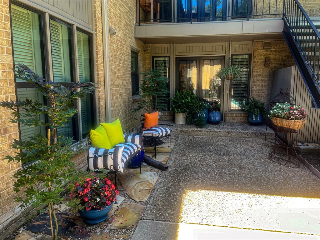 Expansive patio featuring exposed aggregate concrete, brick exterior, and a built-in outdoor staircase