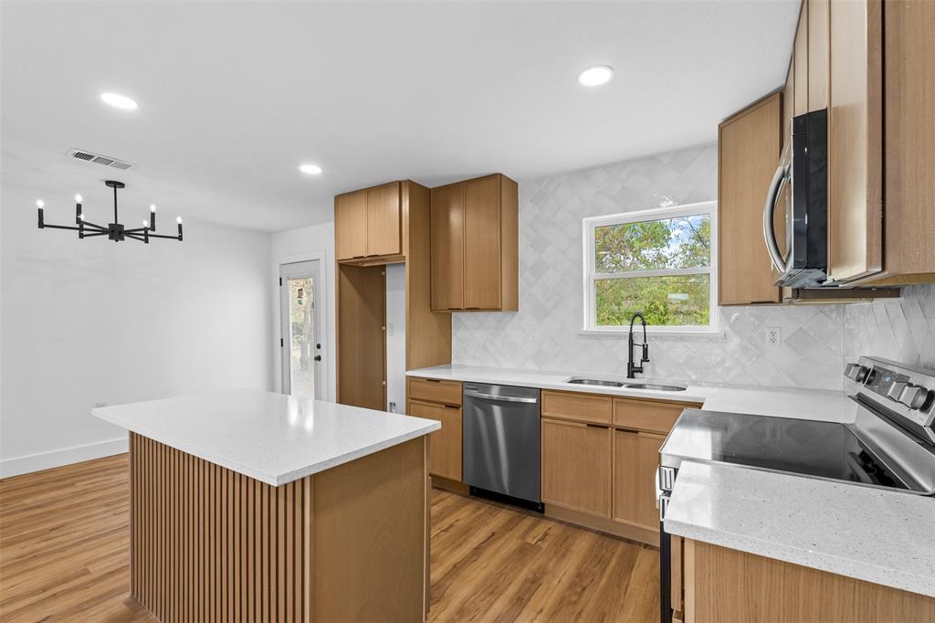 Kitchen featuring wood-finish cabinetry, white countertops, stainless steel appliances, and a tiled backsplash Kitchen featuring wood-finish cabinetry, white countertops, stainless steel appliances, and a tiled backsplash