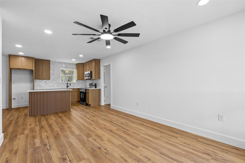 Wood-finish flooring throughout, recessed lighting, and a modern ceiling fan Wood-finish flooring throughout, recessed lighting, and a modern ceiling fan
