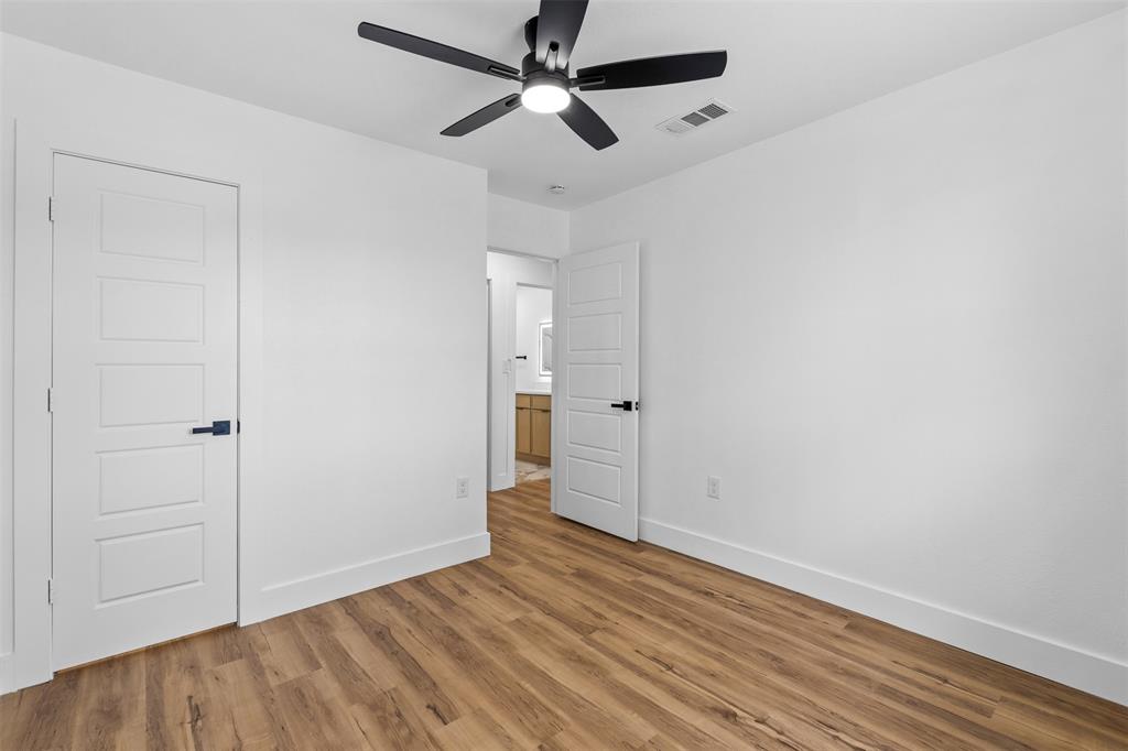 Wood-finish flooring, white walls, and a contemporary ceiling fan with integrated lighting