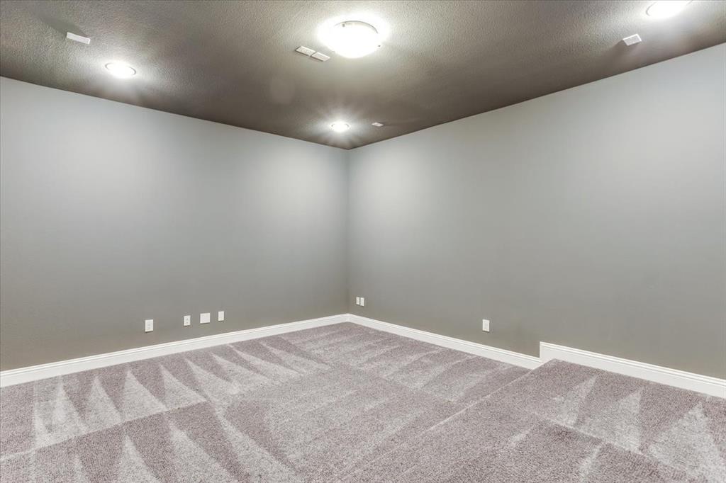 Recessed lighting, flush mount ceiling fixture, gray wall finish, white trim, and gray patterned carpeting