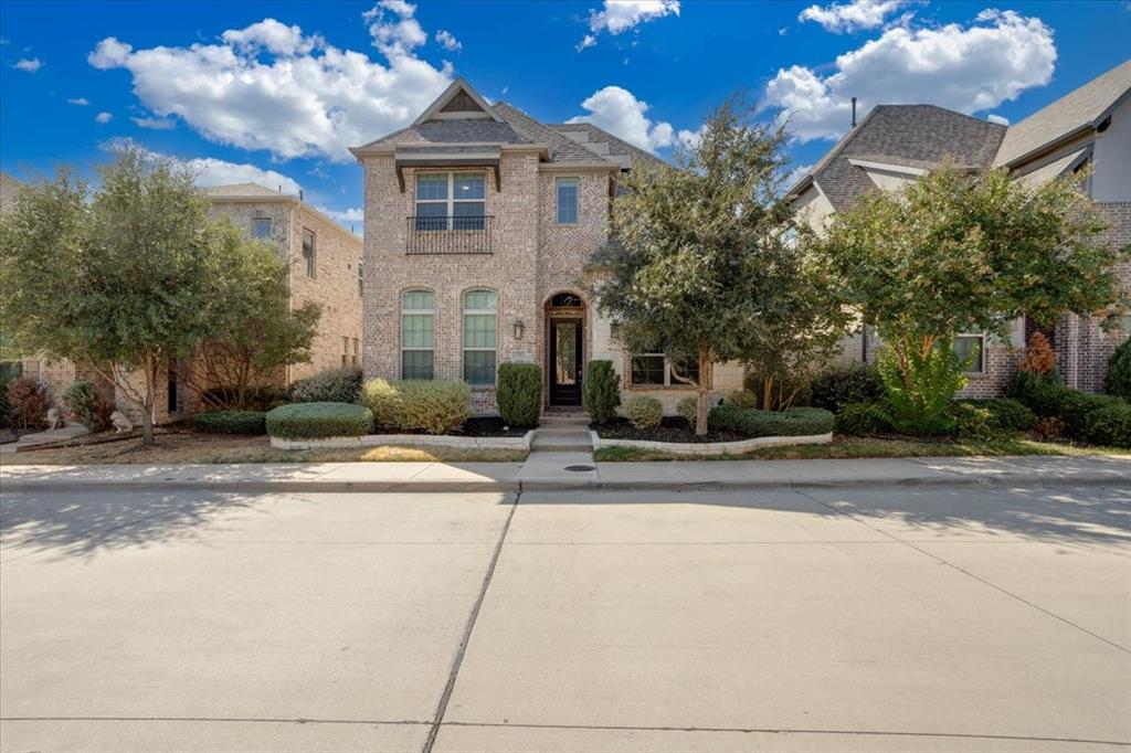 Brick facade with a gabled roofline, arched entry, and mature landscaping Brick facade with a gabled roofline, arched entry, and mature landscaping