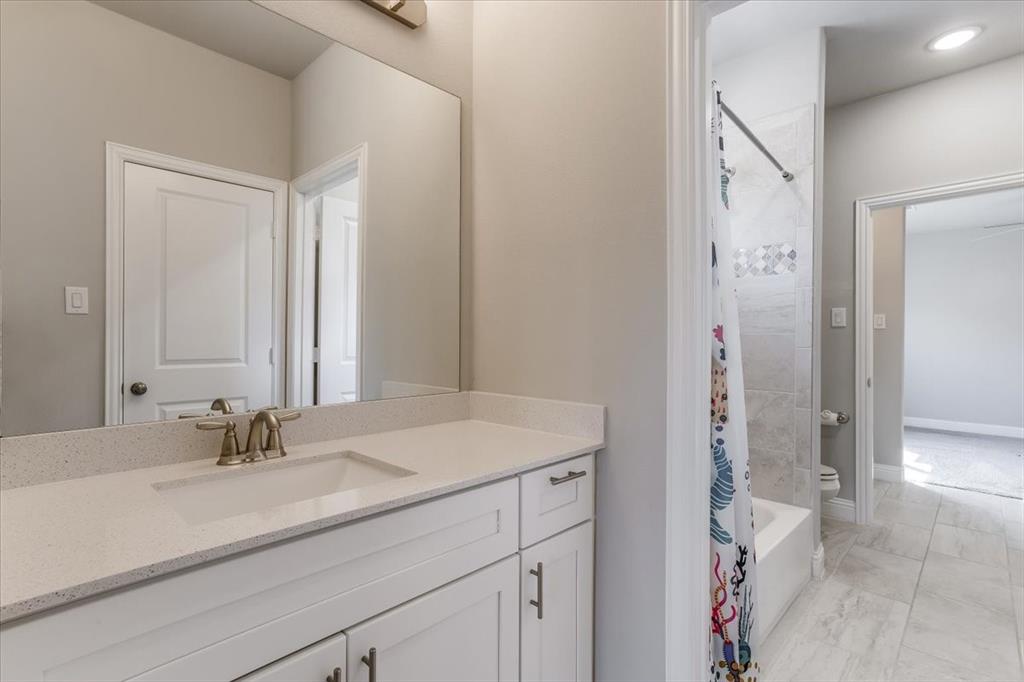 White vanity with integrated sink, light-colored countertop, and brushed nickel faucet