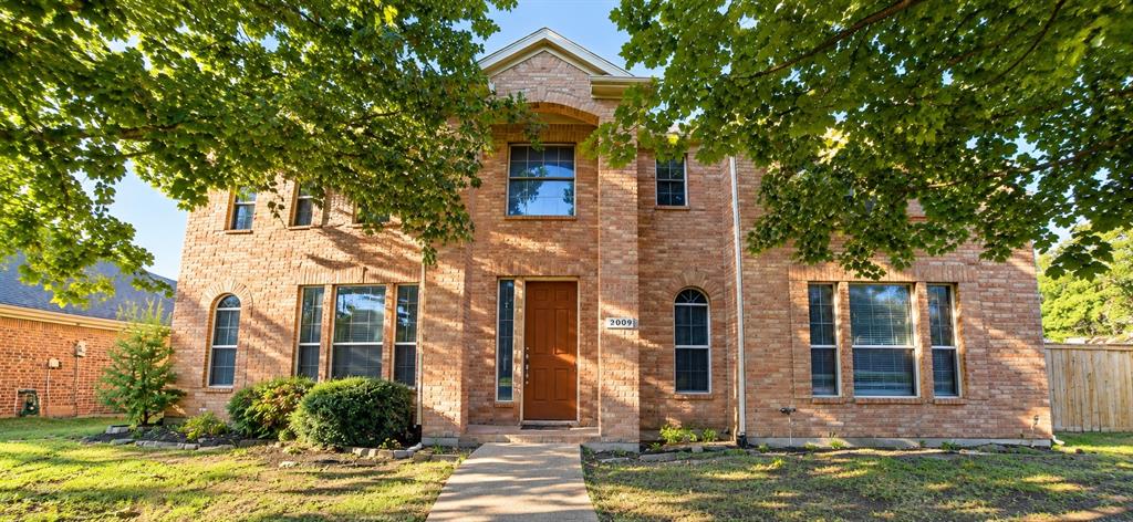 Traditional brick exterior featuring a prominent entryway, a variety of window styles, and established landscaping Traditional brick exterior featuring a prominent entryway, a variety of window styles, and established landscaping