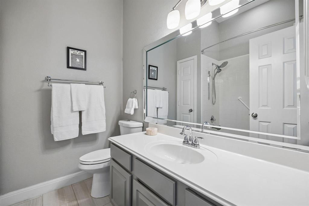 Vanity with an integrated sink and chrome fixtures, ample countertop space, and lower cabinetry