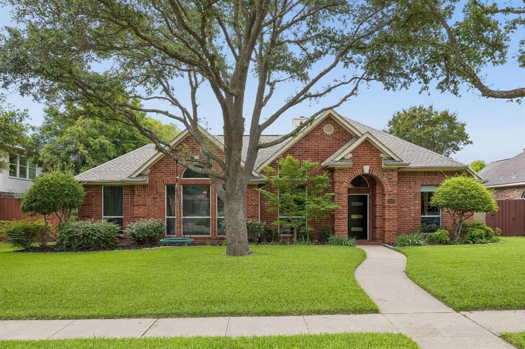 Brick exterior with an arched entryway, large feature window, and mature front yard landscaping Brick exterior with an arched entryway, large feature window, and mature front yard landscaping