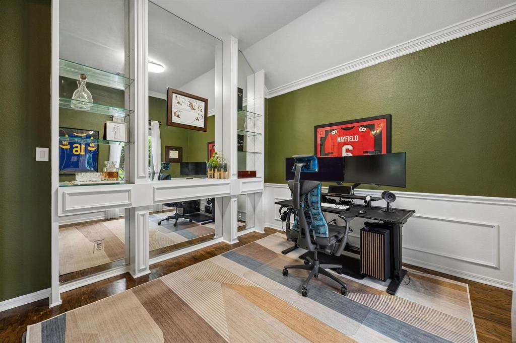 Rich olive green walls, crown molding, and wainscoting details