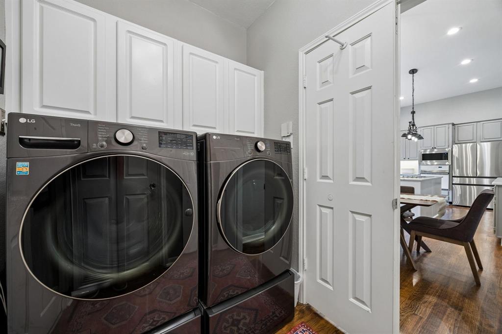 White paneled cabinetry over laundry appliances