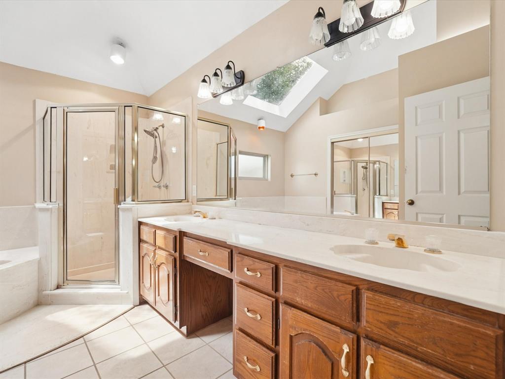 Dual vanity with integrated sinks, wood-finish cabinetry, and a spacious countertop