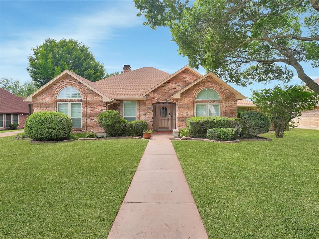 Brick exterior with arched windows, gabled rooflines, and a concrete pathway leading to the entrance Brick exterior with arched windows, gabled rooflines, and a concrete pathway leading to the entrance