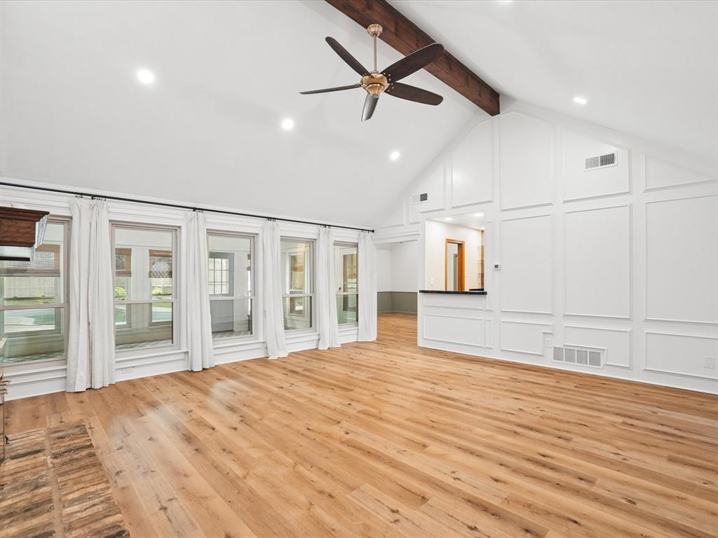 Vaulted ceiling with exposed wood beam, recessed lighting, and a ceiling fan
