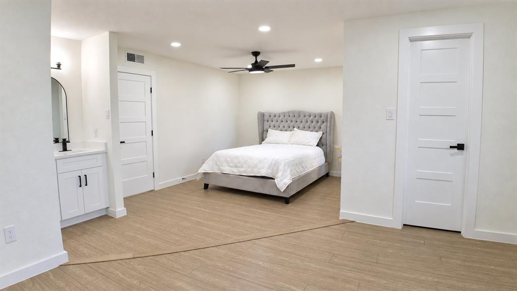 Light-toned wood-finish flooring, recessed lighting, and a ceiling fan with integrated light