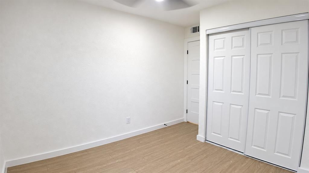 Room featuring a ceiling fan, wood-finish flooring, and white walls