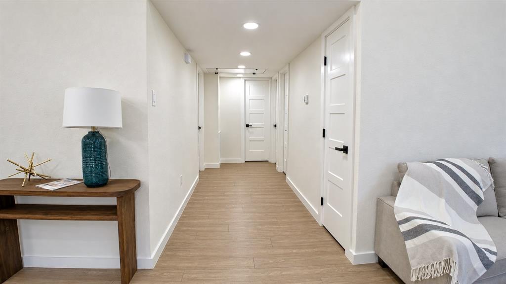 Bright hallway featuring recessed lighting and wood-finish flooring