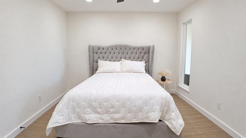 Recessed lighting, ceiling fan, contemporary wall-mounted window, wood-finish flooring, and white wall finishes