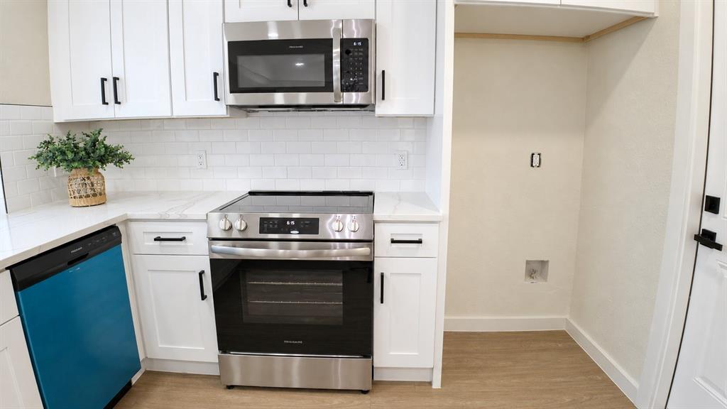 Kitchen featuring white shaker-style cabinetry, stainless steel appliances, a white subway tile backsplash, and light-tone wood-finish flooring