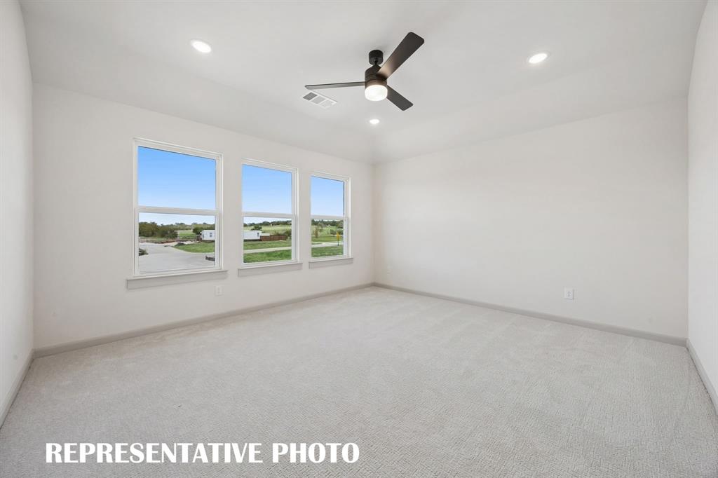Featuring high ceilings, a wall of windows and plush carpet, this dreamy owner's suite was designed for rest and relaxation!  REPRESENTATIVE PHOTO
