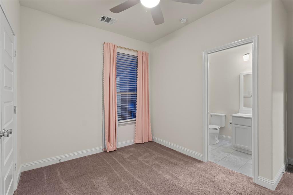 Neutral carpet flooring, overhead ceiling fan, and a window with blinds