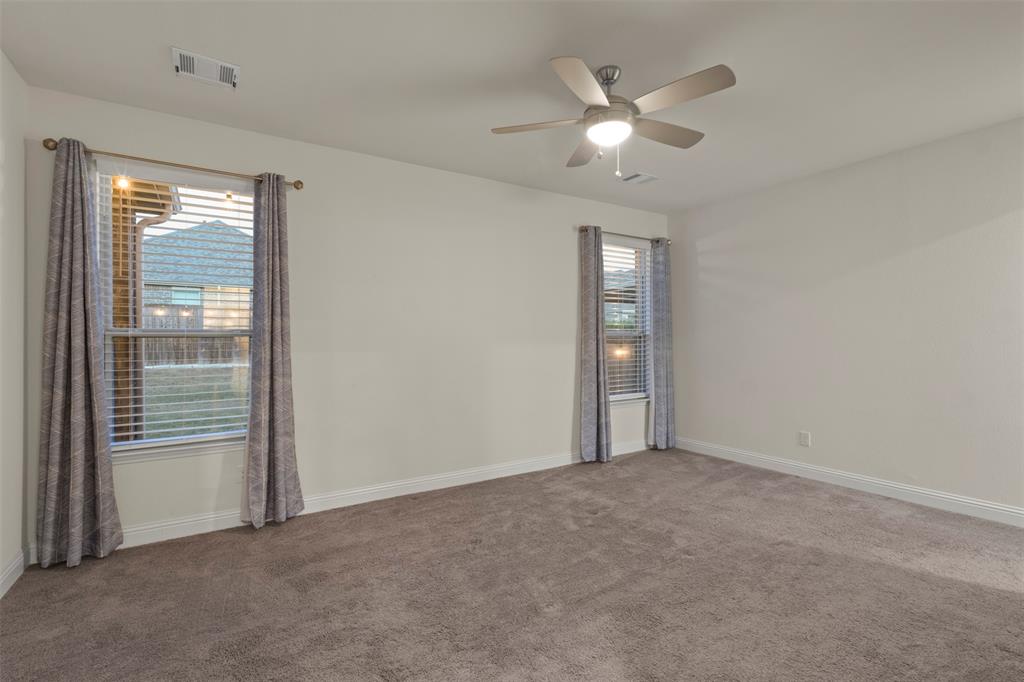Wall-to-wall carpeting and a ceiling fan with integrated lighting