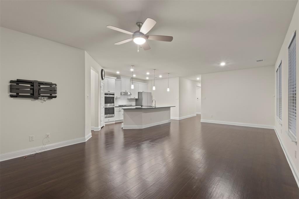 Spacious living area featuring wood-finish flooring, recessed lighting, and a ceiling fan