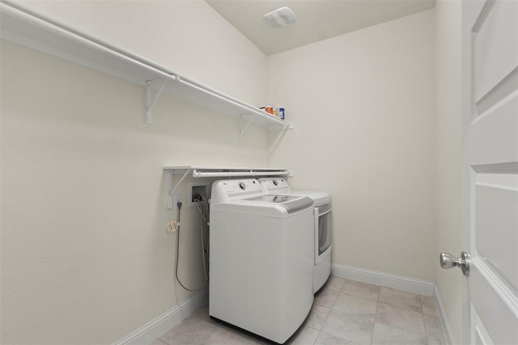 Laundry area with a built-in shelving system, tiled flooring, and a paneled door