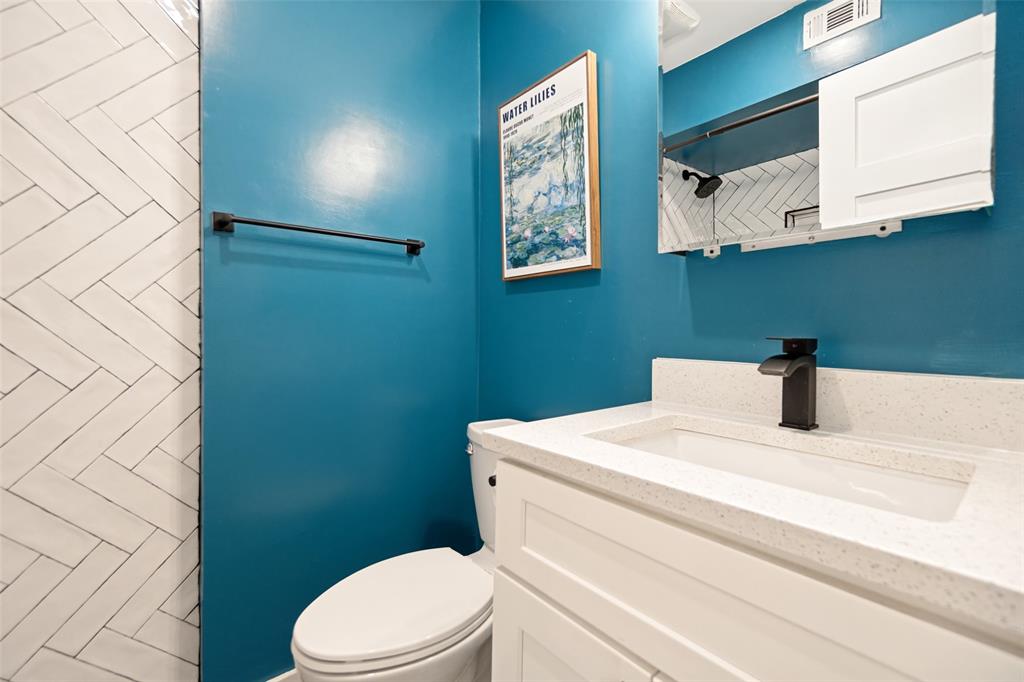 Vanity with an integrated rectangular sink, white countertop, white shaker-style cabinetry, and a matte black faucet