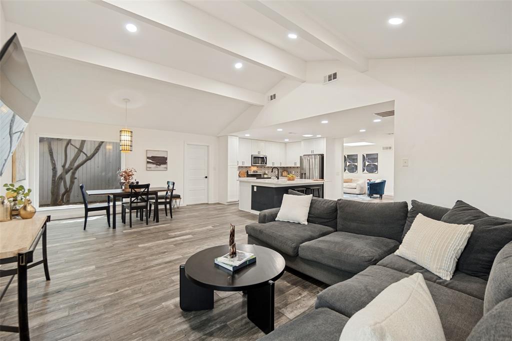 Vaulted ceiling with recessed lighting, wood-finish flooring, and a dining area with a window Vaulted ceiling with recessed lighting, wood-finish flooring, and a dining area with a window
