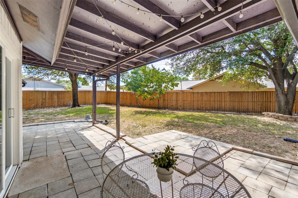 Covered patio featuring a paved surface, direct backyard access, and string lighting