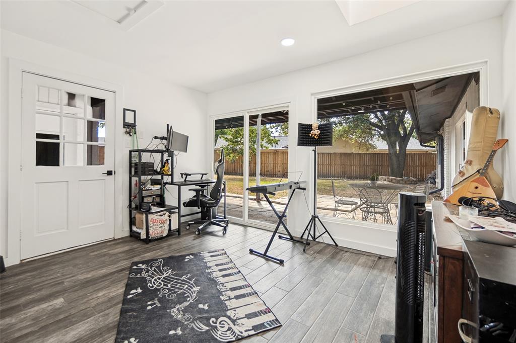 Wood-finish flooring, white paneled French door, large sliding glass door, white walls, and recessed lighting