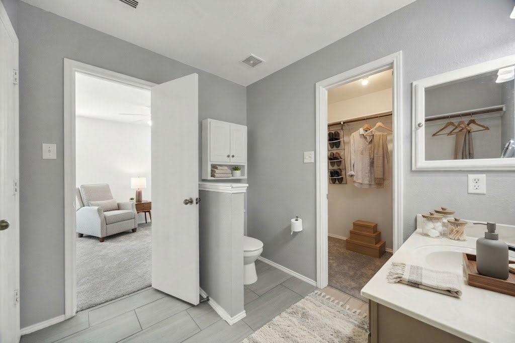 Bathroom featuring light gray wall paint, tile flooring, a white vanity with a single sink, and a mirrored medicine cabinet