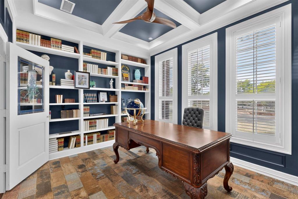 Built-in floor-to-ceiling shelving, recessed tray ceiling, custom wood-finish flooring, multi-pane window shutters, and integrated ceiling fan
