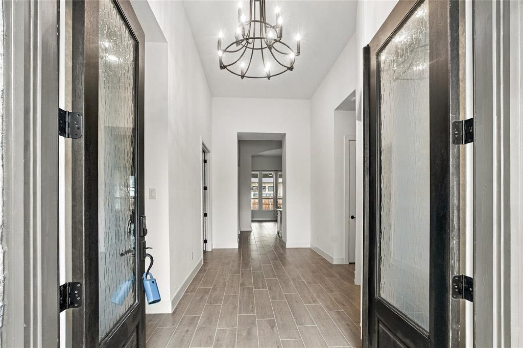 Entryway featuring an architectural chandelier, wood-finish flooring, and white walls