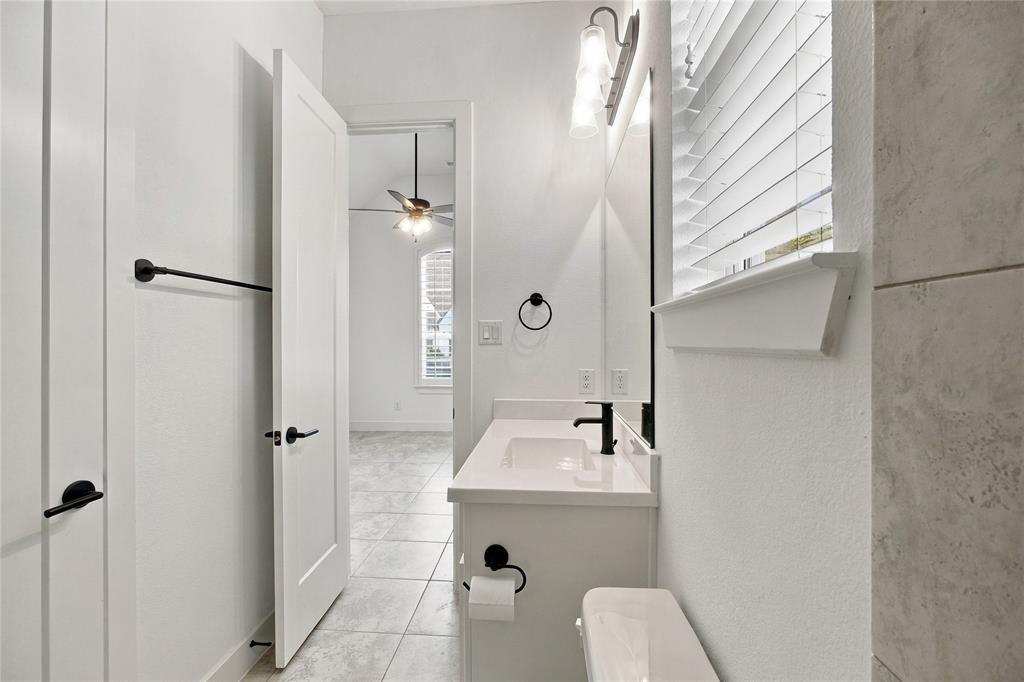 Full bathroom ensuite third bedroom featuring a single vanity with a white countertop, matte black faucet