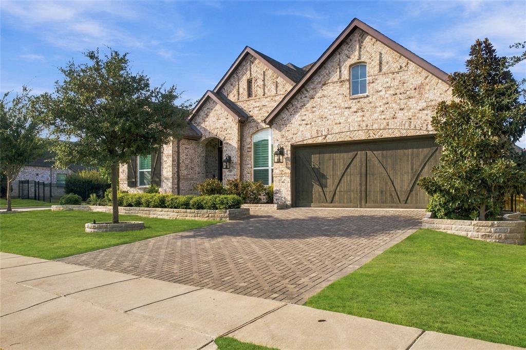 Brick exterior with an arched entry and dark-toned garage door