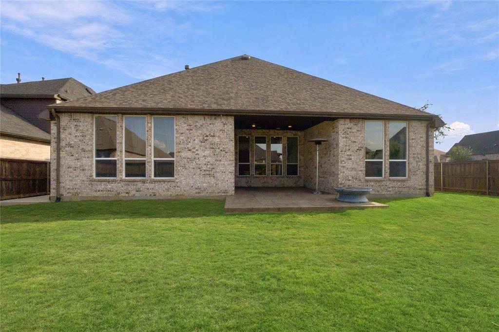 Expansive backyard featuring a covered patio, and multi-paned windows