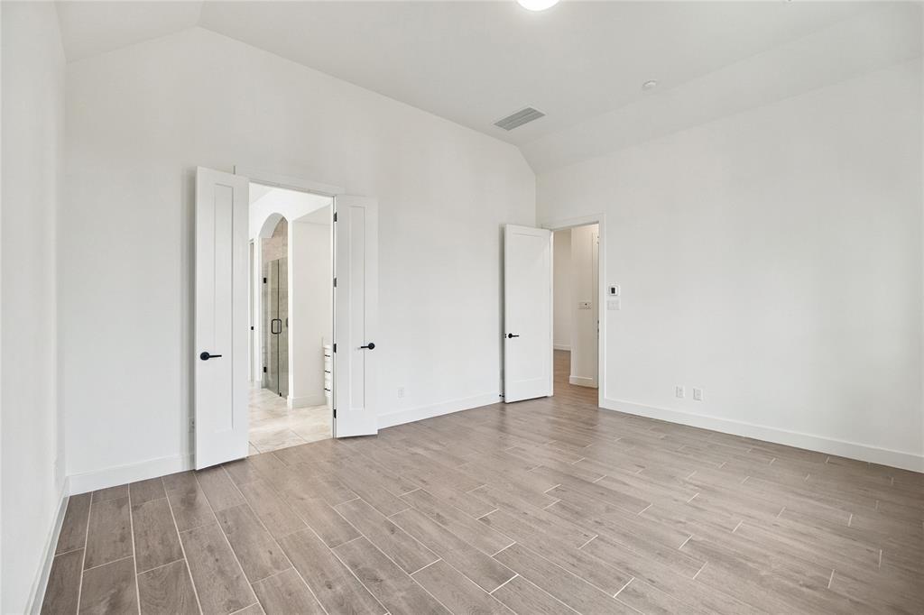 1st primary bedroom 14x17 featuring vaulted ceiling, wood-finish flooring