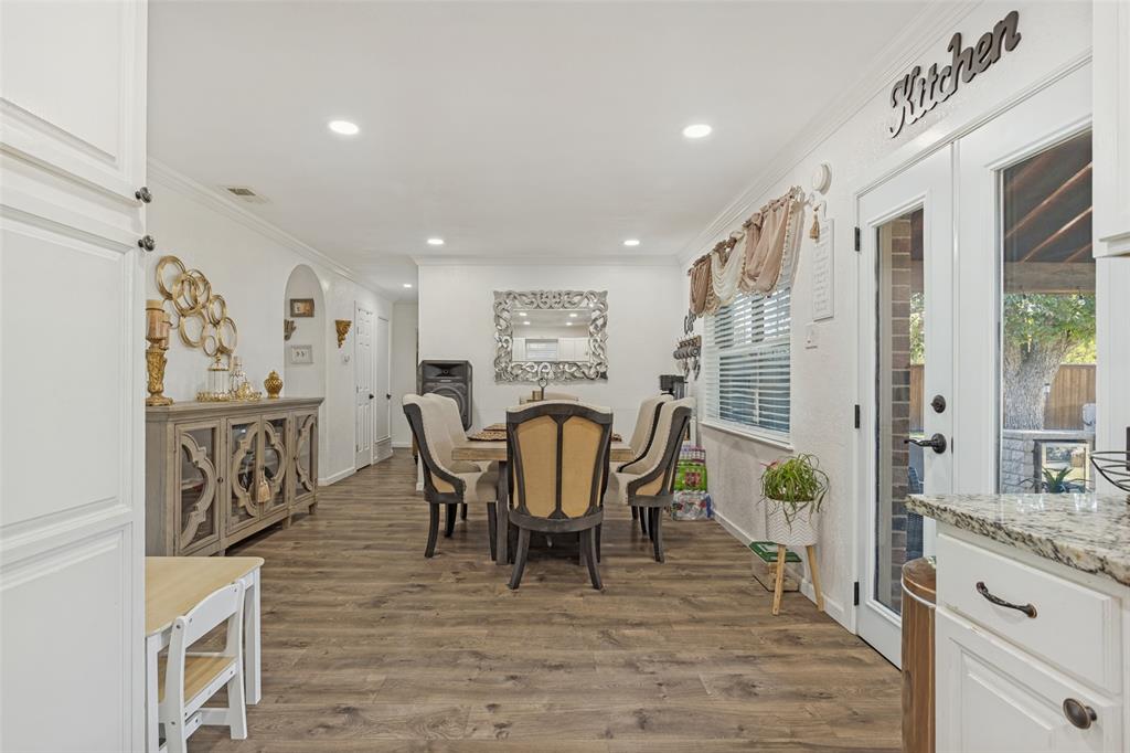 Open-concept dining area featuring wood-finish flooring, recessed lighting, and full-glass French doors