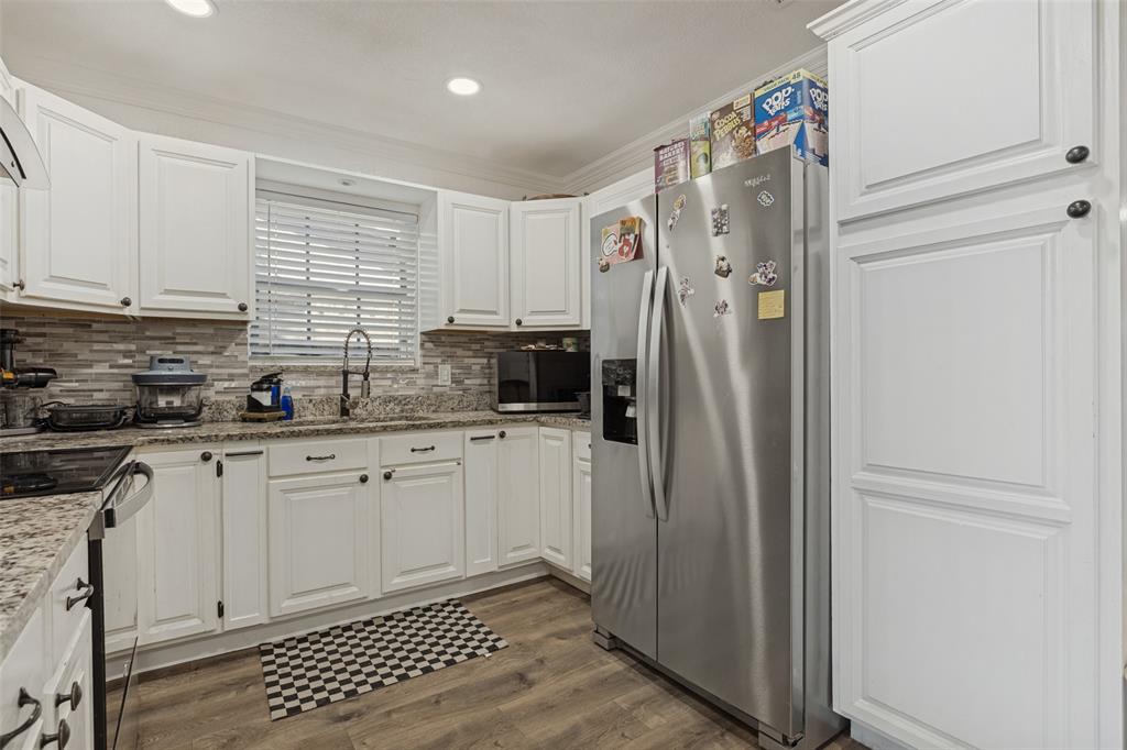 Kitchen featuring white cabinetry, stone-surface countertops, stone tile backsplash, wood-finish flooring, and recessed lighting