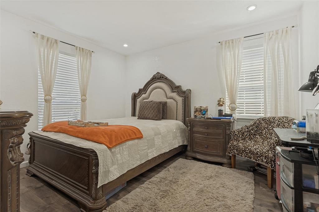 Neutral interior space featuring wood-finish flooring, recessed lighting, and dual windows with horizontal blinds