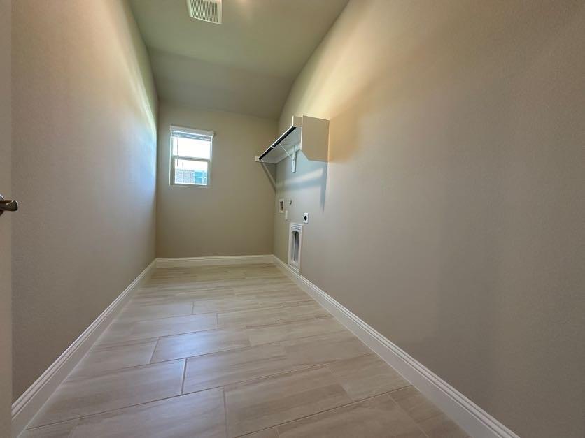 Utility room featuring tile flooring, a window, and built-in shelving