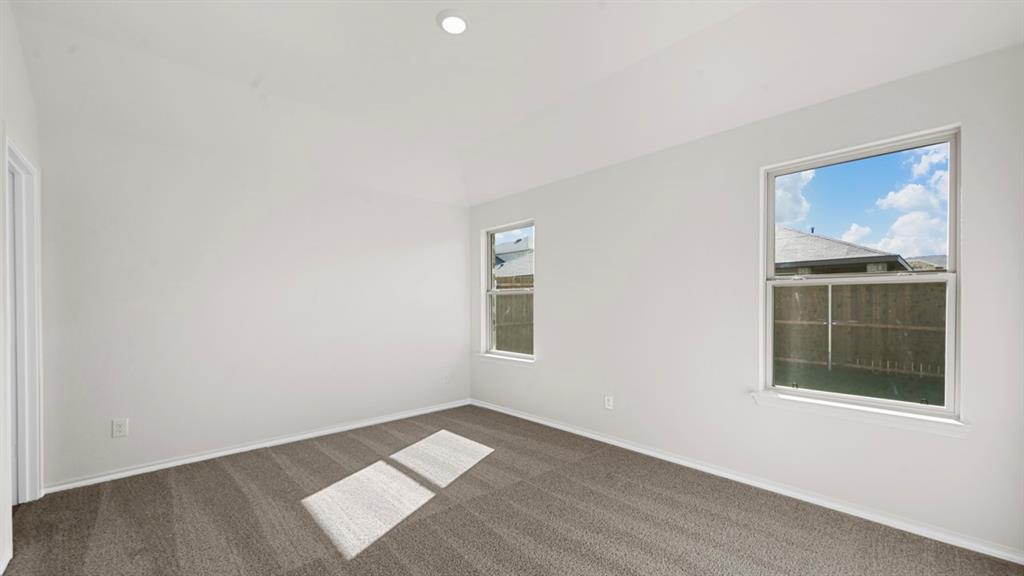 Neutral paint palette with recessed lighting, two windows, and gray carpet flooring