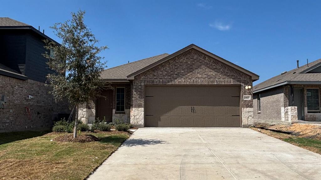 Brick exterior with stone accents, attached garage, concrete driveway, and a front entry Brick exterior with stone accents, attached garage, concrete driveway, and a front entry