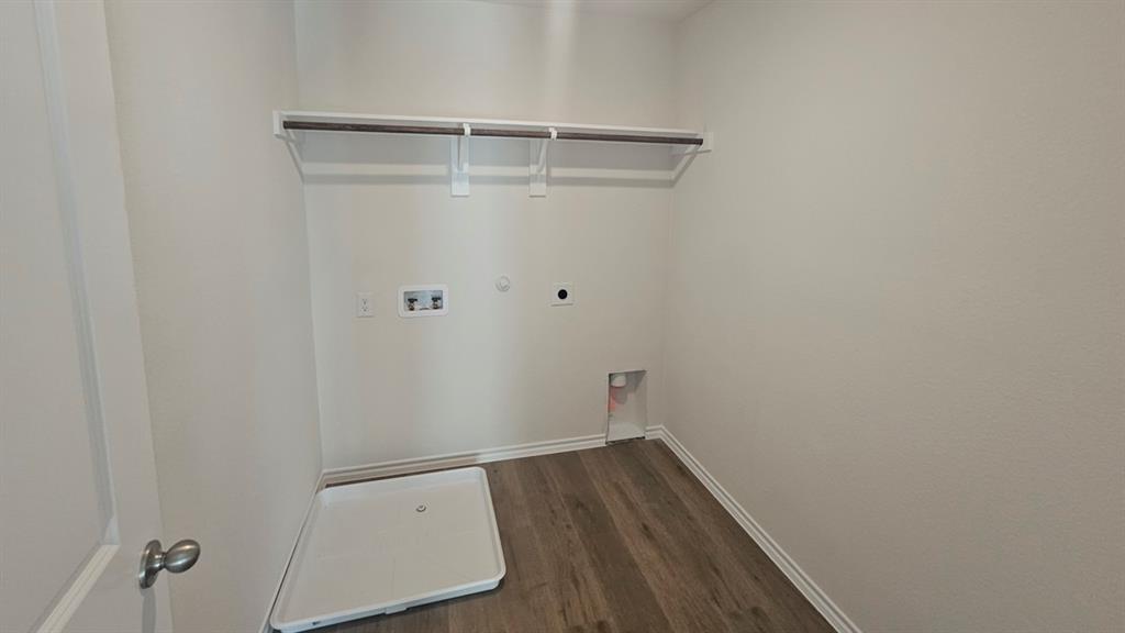 Dedicated utility space featuring wood-finish flooring, white baseboards, and light neutral wall paint